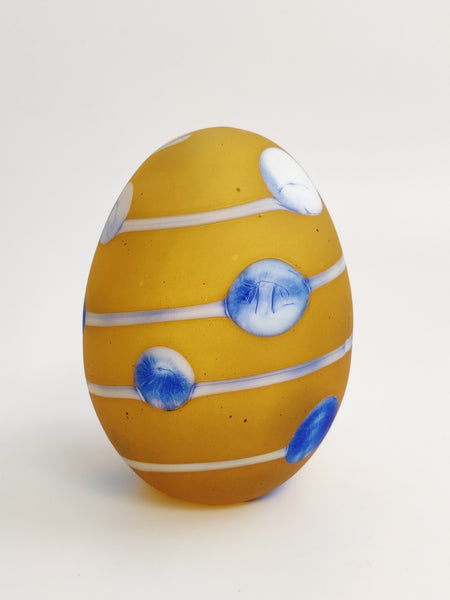 Decorative egg with blue and white patterns on a light gray background