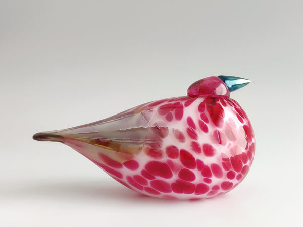 Glass bird figurine with pink and white speckled pattern on a white background