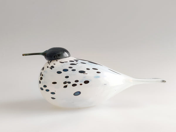 Decorative glass piece with dark green and blue speckles on a white body